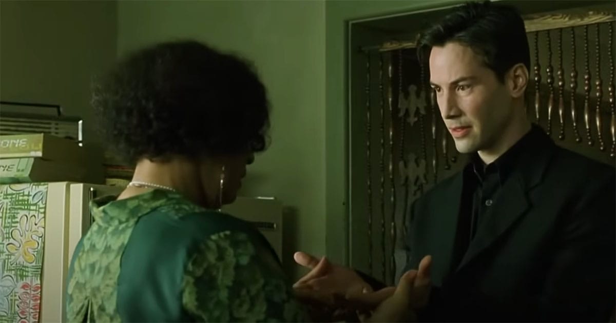 Neo stands across from the Oracle during a pivotal conversation in "The Matrix."