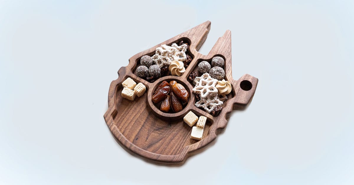 Millennium Falcon-shaped wooden charcuterie board filled with snacks and treats, perfect for a Star Wars-themed Mother’s Day gift.