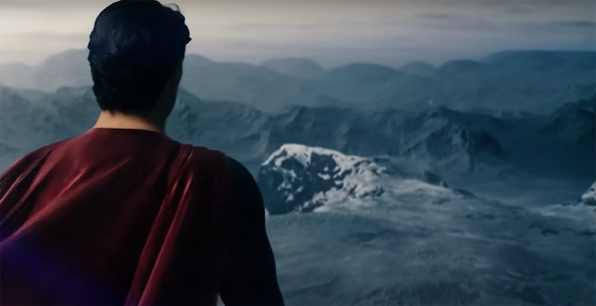 Superman stands overlooking a vast, icy mountain range, symbolizing quiet strength and his enduring moral purpose in the closing theme of "Man of Steel."
