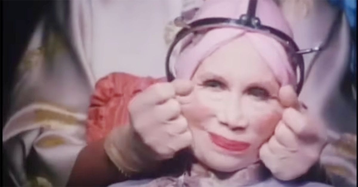 A woman in Terry Gilliam’s "Brazil" (1985) undergoing a surreal cosmetic procedure, her face stretched by clamps and wires in a satirical take on vanity and technology gone awry.