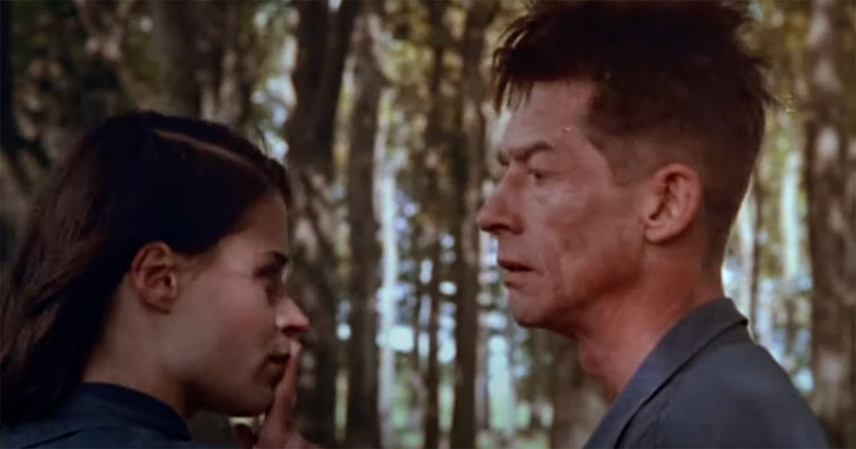 Suzanna Hamilton as Julia signals silence to John Hurt’s Winston during a secret meeting in the forest in the 1984 film Nineteen Eighty-Four.