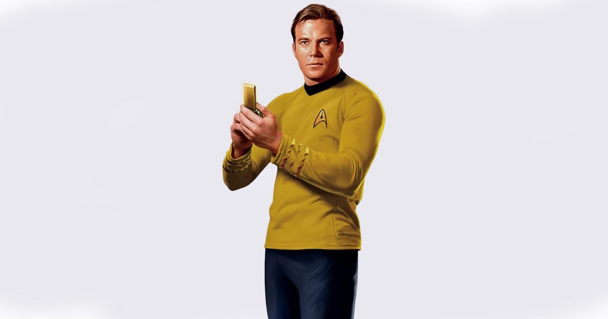 Life-size cardboard cutout of Captain James T. Kirk holding a communicator, wearing his iconic gold Starfleet uniform against a white background.