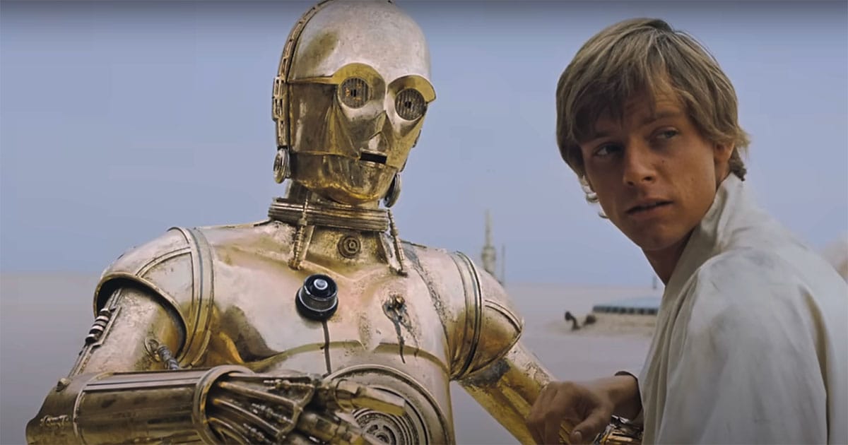 C-3PO standing beside Luke Skywalker on the desert planet Tatooine in Star Wars showing the droid’s rigid stance