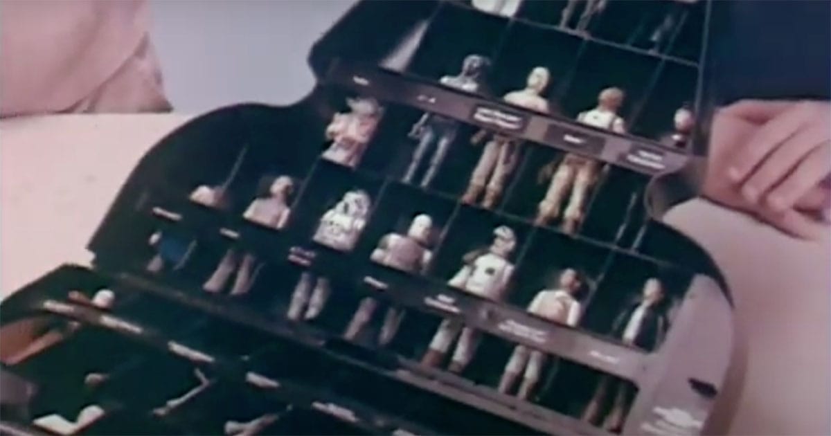 Open Darth Vader-shaped Star Wars action figure storage case showing rows of vintage figures in compartments.