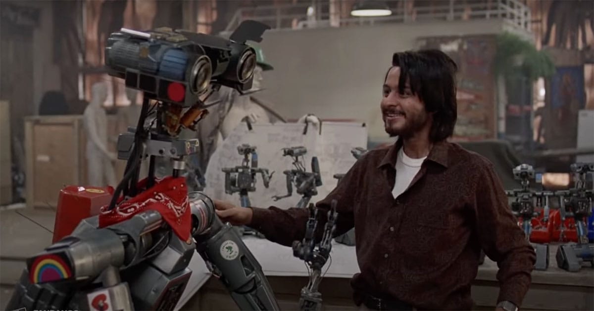 Johnny 5 from "Short Circuit" sharing a friendly moment with Ben in a workshop.