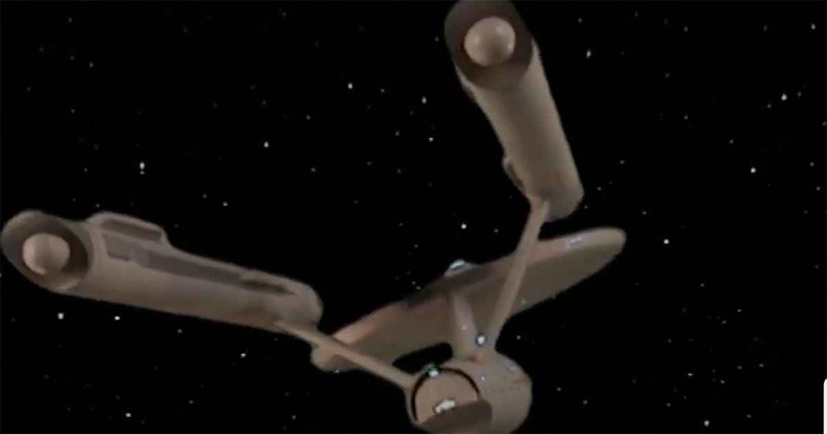 Port-side view of the U.S.S. Enterprise NCC-1701 showing visible hull damage, symbolizing her role as a beloved and vulnerable part of "Star Trek: The Original Series."