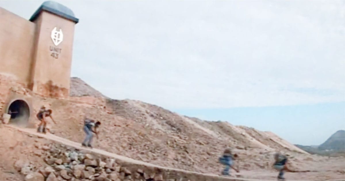 Teenagers on roller skates fleeing Unit 47 into a barren desert landscape in the science fiction film Solarbabies