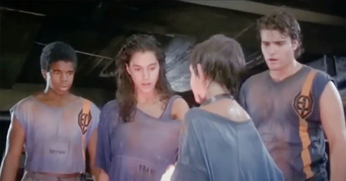 Teenagers in torn uniforms stare in awe at a glowing orb representing Bodhi in Solarbabies.