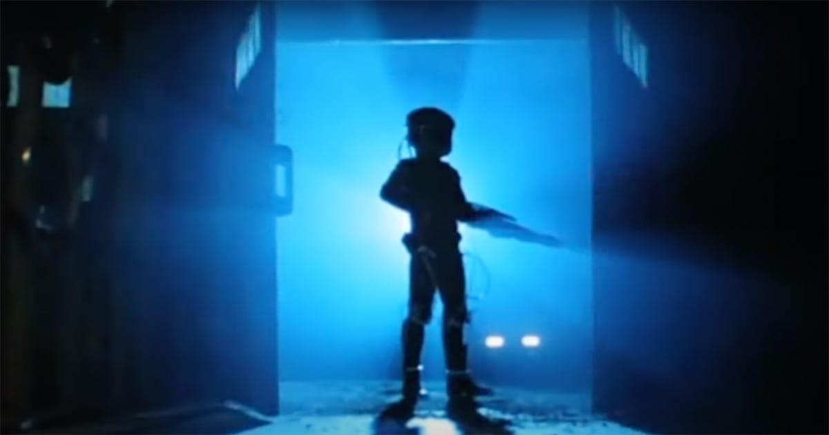 Silhouette of the Wraith character standing in a doorway flooded with blue light, with headlights from the Dodge M4S Turbo Interceptor glowing in the background.