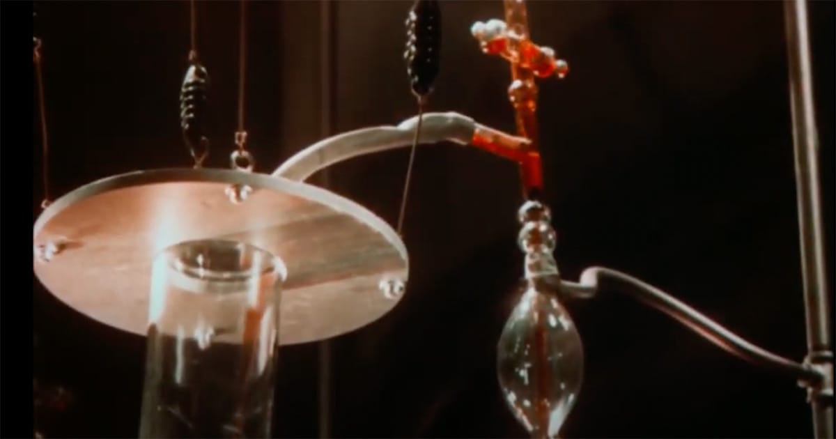 Close-up of vintage laboratory equipment from the 1932 film "Doctor X" showing tubes and glassware in two-strip Technicolor.