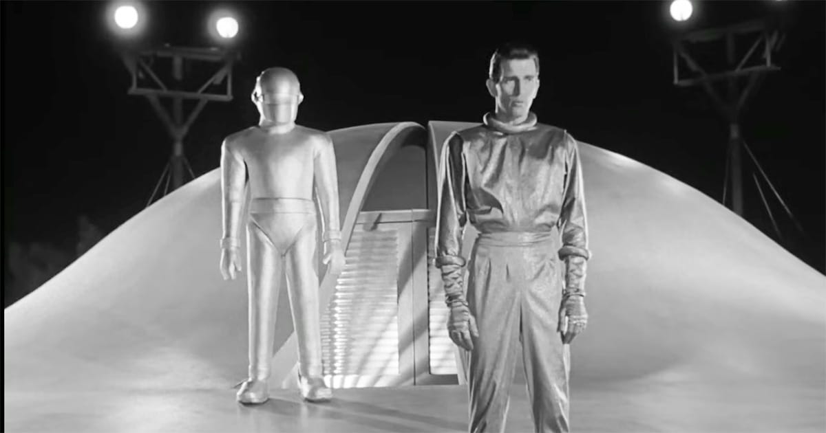 Klaatu and Gort stand before the open saucer doorway in The Day the Earth Stood Still (1951) poised to deliver their warning.