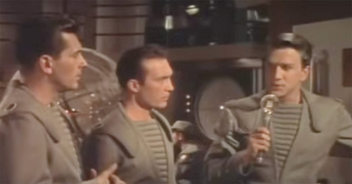 Commander John J. Adams confers with his crew in the control room of the C-57D during the 1956 science fiction film "Forbidden Planet," before landing on the mysterious world of Altair IV.