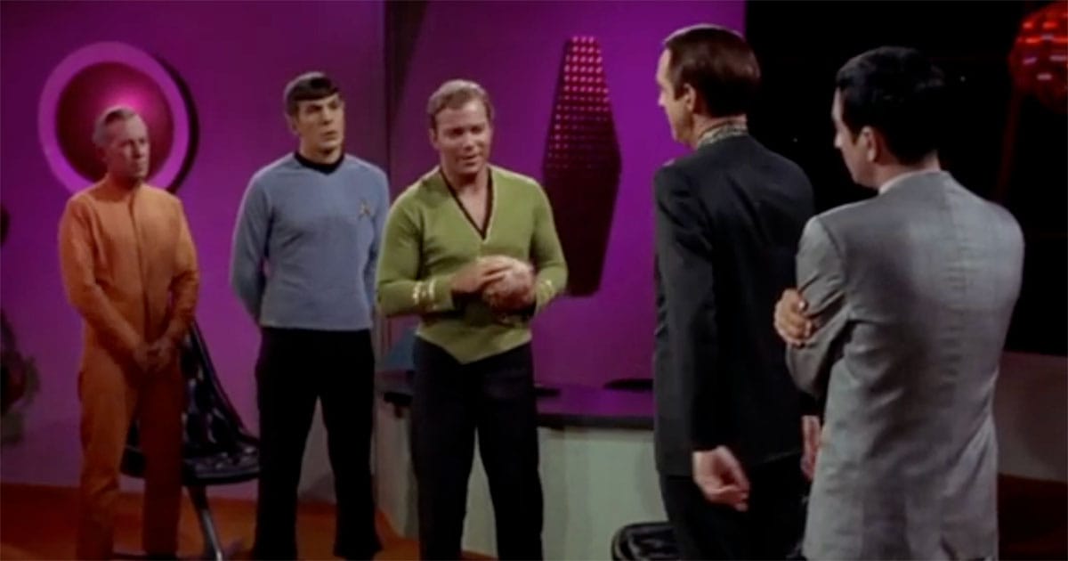 Captain Kirk holding a tribble while speaking with Commissioner Baris in “The Trouble with Tribbles” episode of Star Trek.