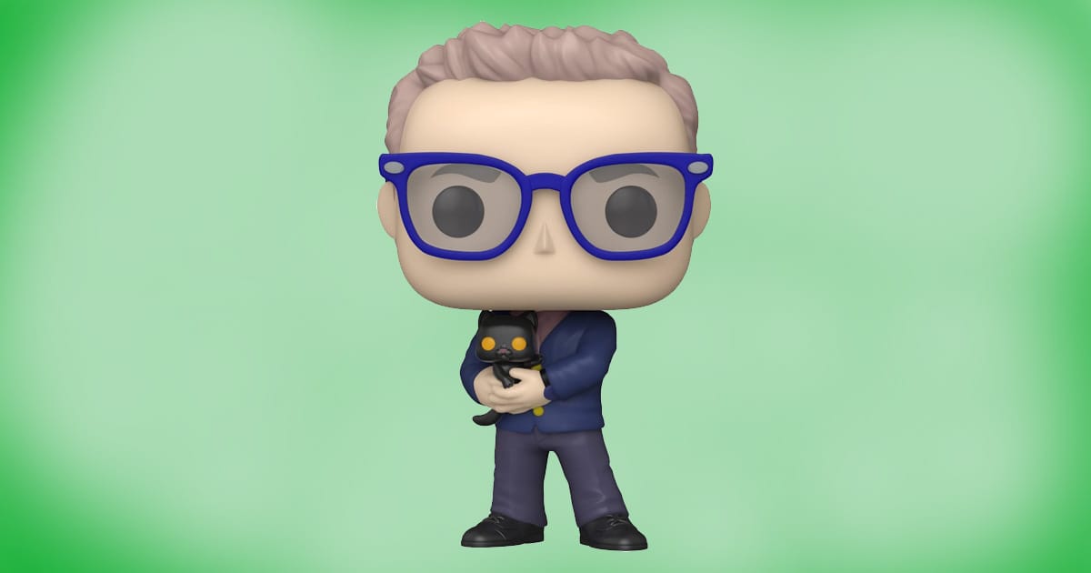 Funko POP vinyl figure of The Analyst from The Matrix Resurrections wearing blue glasses and suit, holding a small black cat collectible toy.