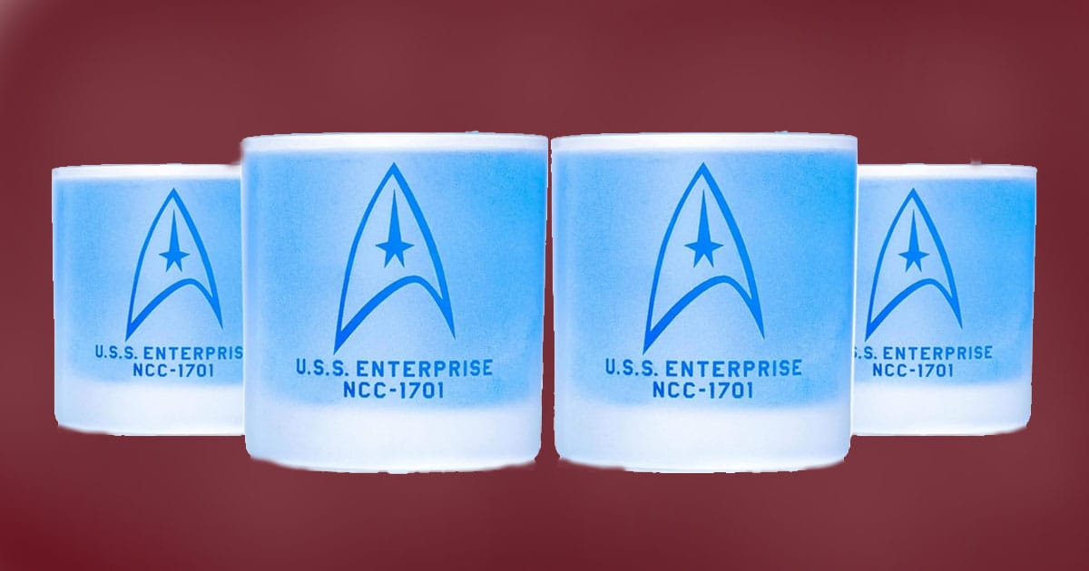 Set of four Star Trek whiskey glasses with etched command insignia and USS Enterprise NCC-1701 design.