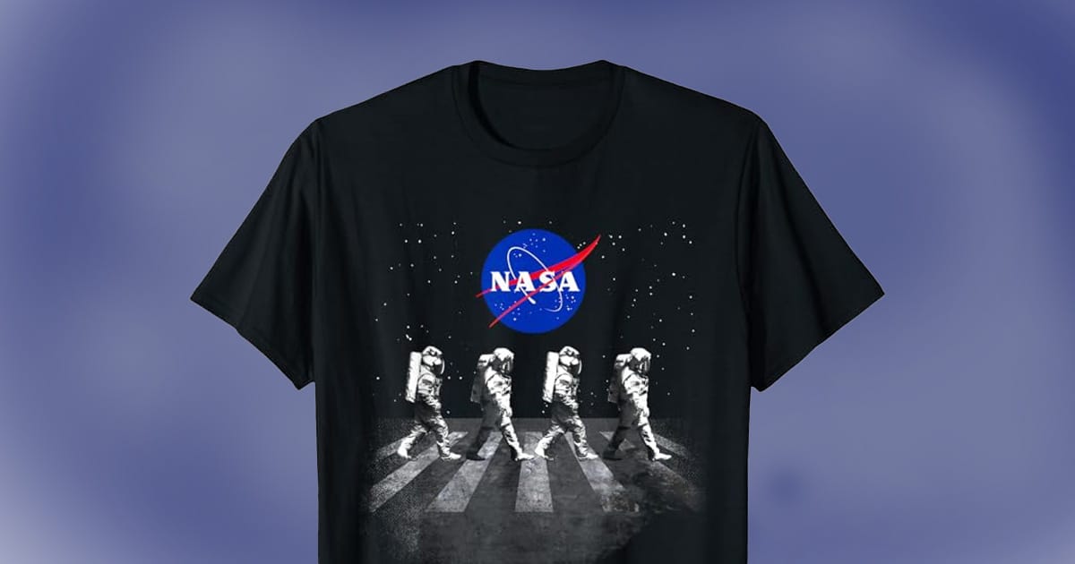 Black NASA T-shirt featuring four astronauts walking in a crosswalk design under the NASA logo with a starry background.