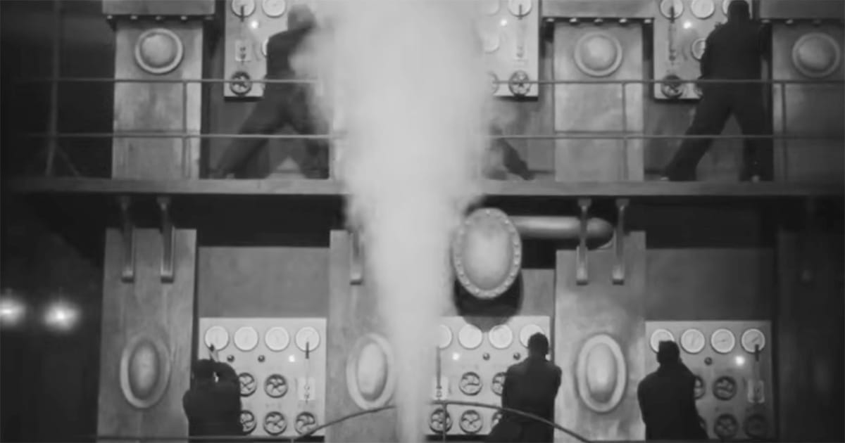 Workers in Metropolis (1927) operating massive industrial control panels surrounded by steam and gauges, symbolizing the mechanization of human labor.