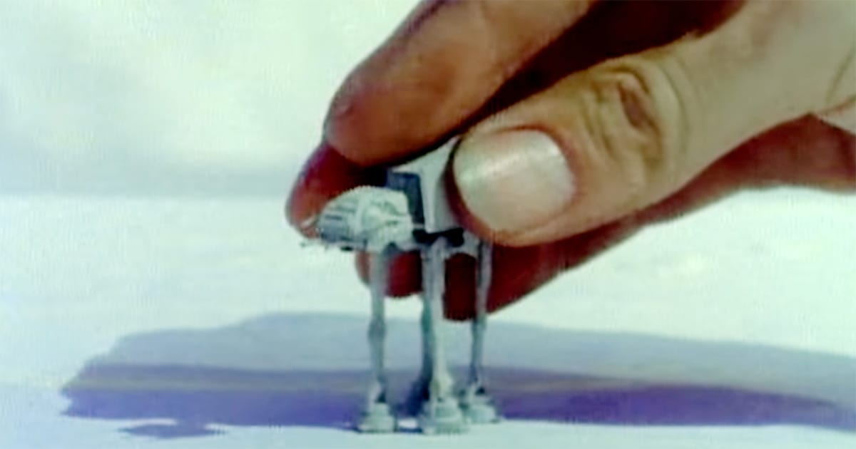AT-AT miniature model held by hand on snow set for "Star Wars" visual effects.