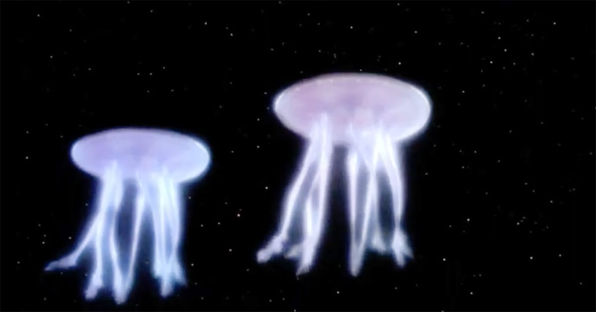 Two glowing spacefaring jellyfish-like aliens drift against the stars in Star Trek: The Next Generation episode “Encounter at Farpoint.”