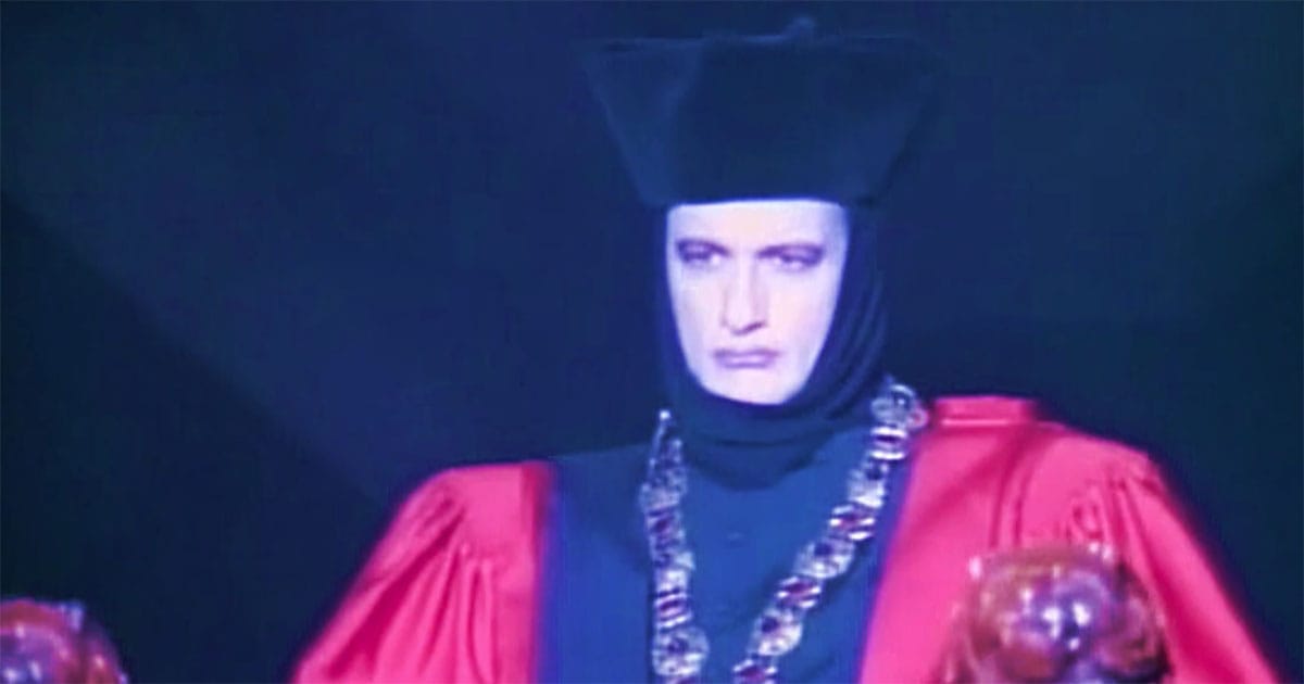 Q dressed in red judicial robes and headdress during the courtroom scenes of Star Trek: The Next Generation episode “Encounter at Farpoint.”