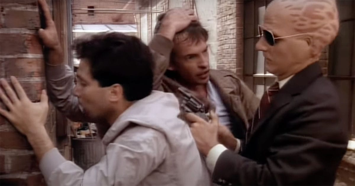 Alien detective George Francisco wearing sunglasses arrests a suspect while partner Matthew Sikes assists in Alien Nation TV series.