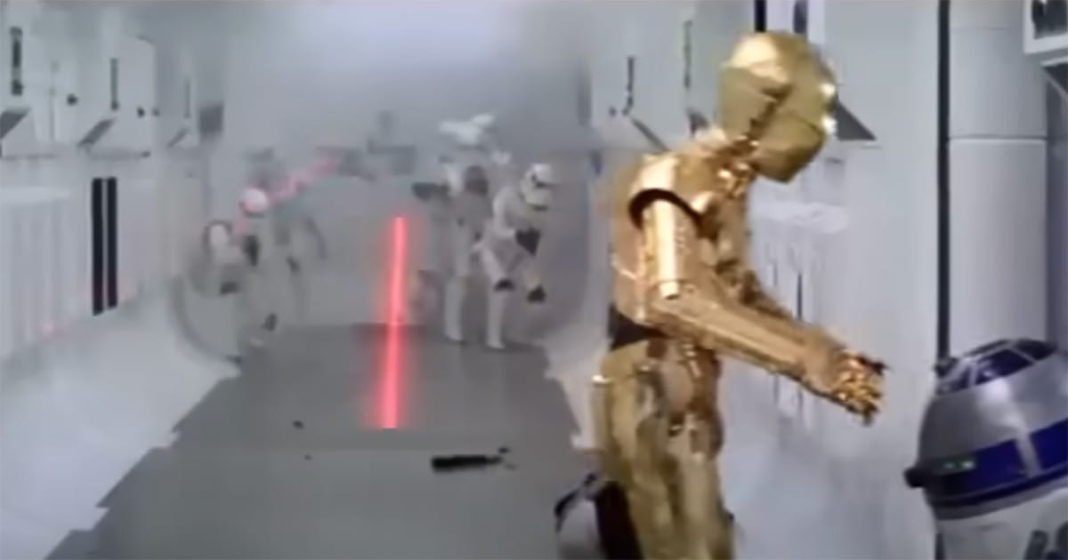 Stormtroopers firing blasters in a white corridor while C-3PO and R2-D2 escape, illustrating the origin of stormtrooper inaccuracy in “Star Wars.”