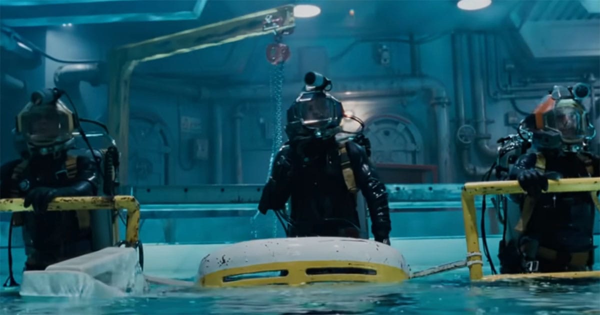 Three divers in deep-sea suits inside Deepcore underwater drilling platform from The Abyss.