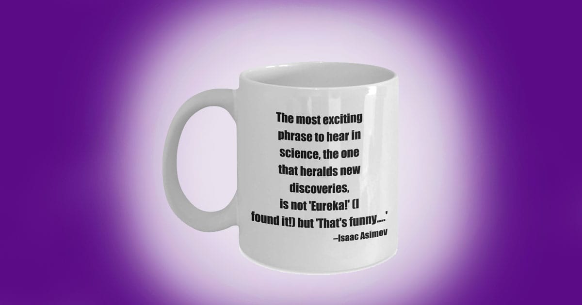 White coffee mug printed with Isaac Asimov quote about discovery and curiosity in science.
