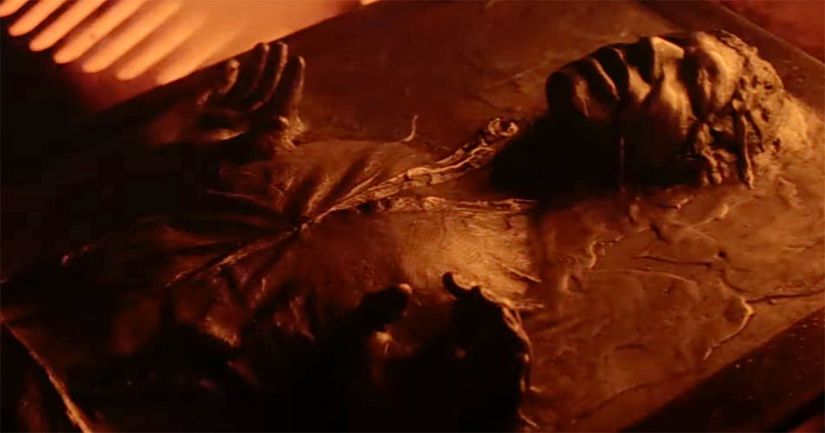 Han Solo encased in carbonite on Cloud City, glowing in orange light from the freezing chamber.