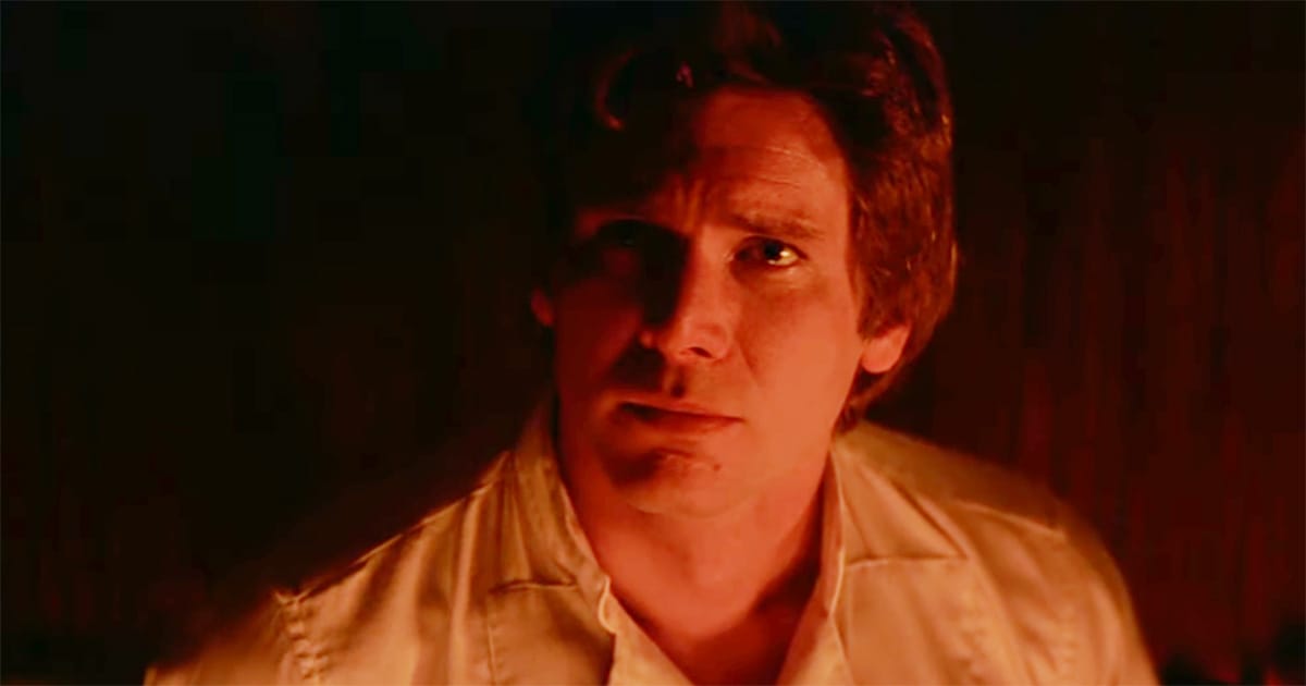 Han Solo looks forward in dim red light, calm and determined in the moments before being frozen in carbonite.