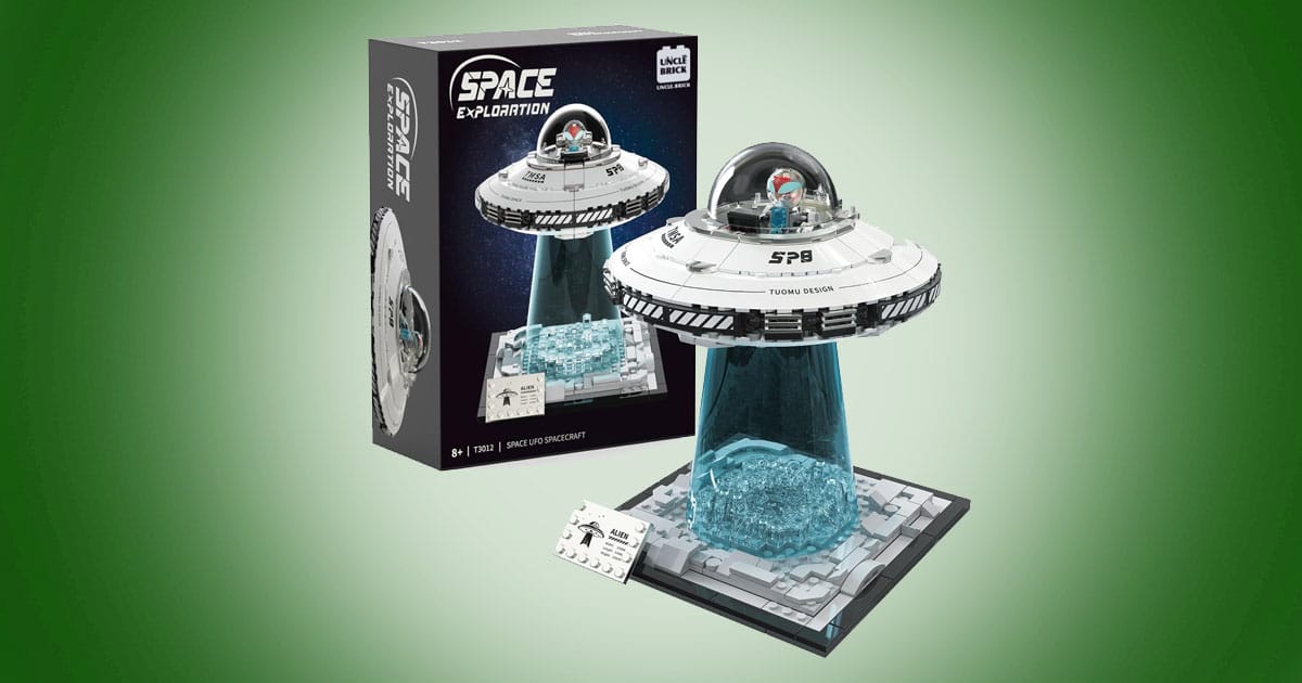 Lego-compatible UFO spaceship building set with glowing blue light beam and packaging displayed on green background.
