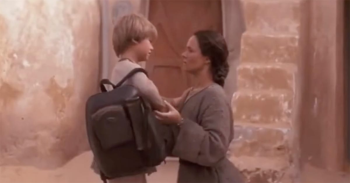 Shmi Skywalker holding young Anakin’s shoulders as he prepares to leave their home on Tatooine.
