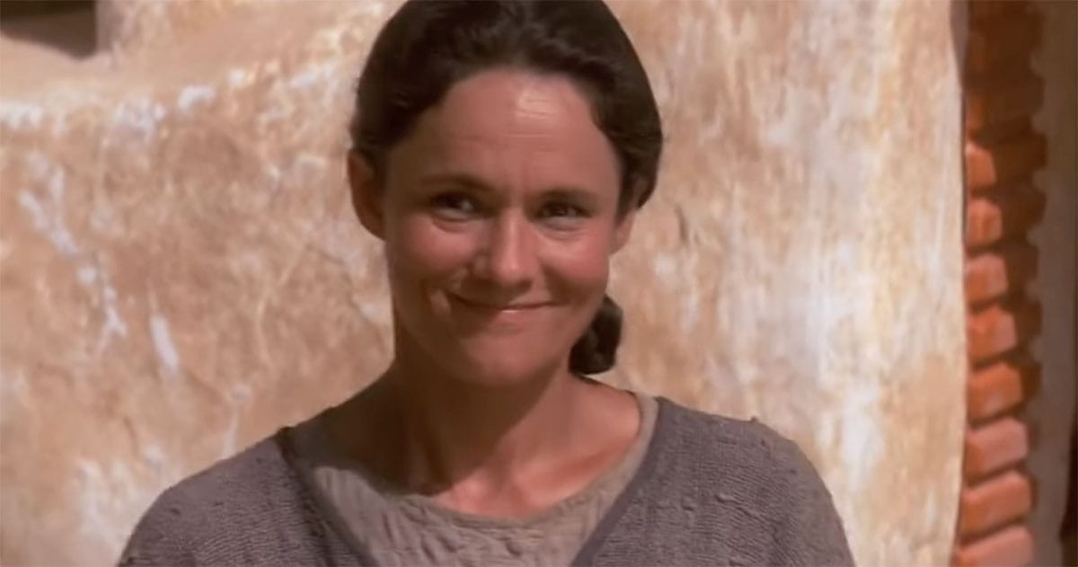 Shmi Skywalker smiling outside her home on Tatooine.