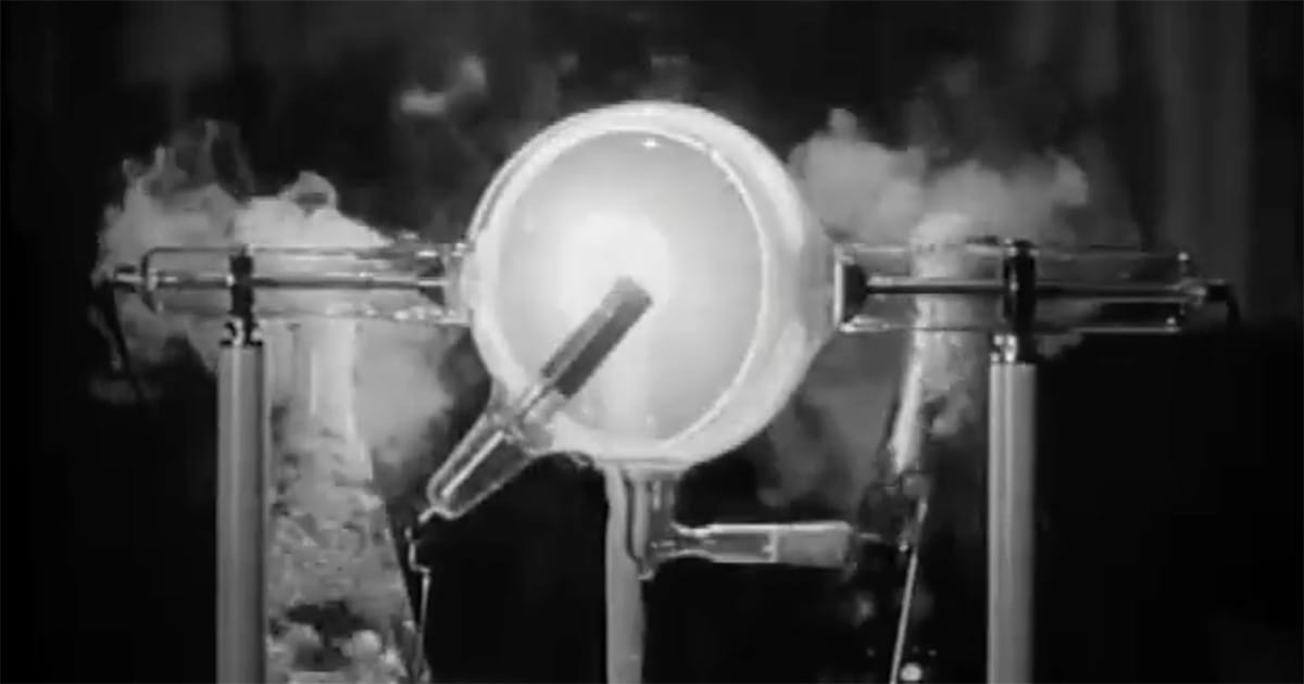 A man examines a glowing laboratory lamp in a dark room from the classic film “The Return of Doctor X.”