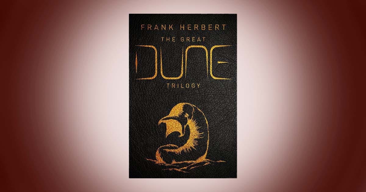 Cover of The Great Dune Trilogy by Frank Herbert classic science fiction novel collection black and gold edition featuring sandworm design.