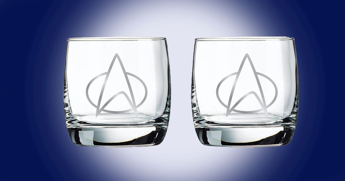 Star Trek The Next Generation whiskey glasses set of two with etched Starfleet delta insignia shown on a blue background.