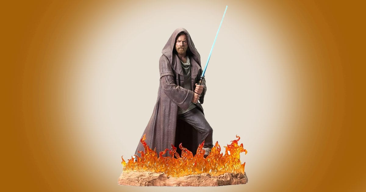 Obi-Wan Kenobi statue with blue lightsaber standing amid flames from Star Wars series.