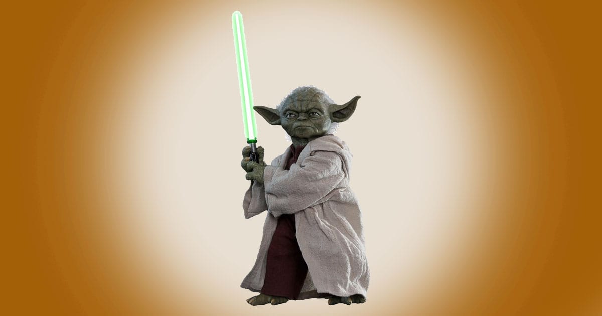 Yoda sixth scale figure holding a green lightsaber against a warm background.