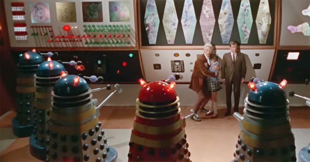 Dr. Who and companions stand in a control room surrounded by Daleks in the 1965 film Doctor Who and the Daleks.