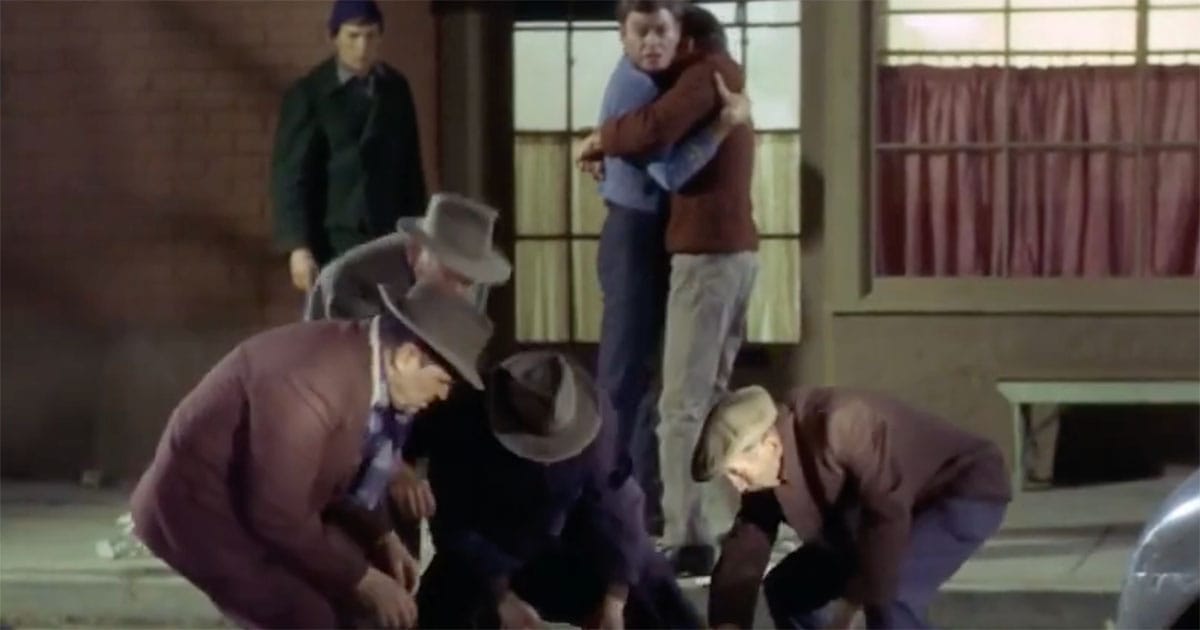 Dr. McCoy holds Captain Kirk on a city street after Edith Keeler is killed in Star Trek The City on the Edge of Forever.