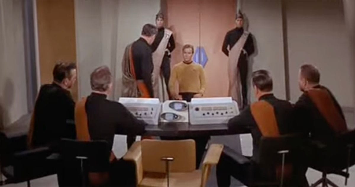 Captain Kirk addresses planetary leaders in Star Trek A Taste of Armageddon during a war tribunal scene.