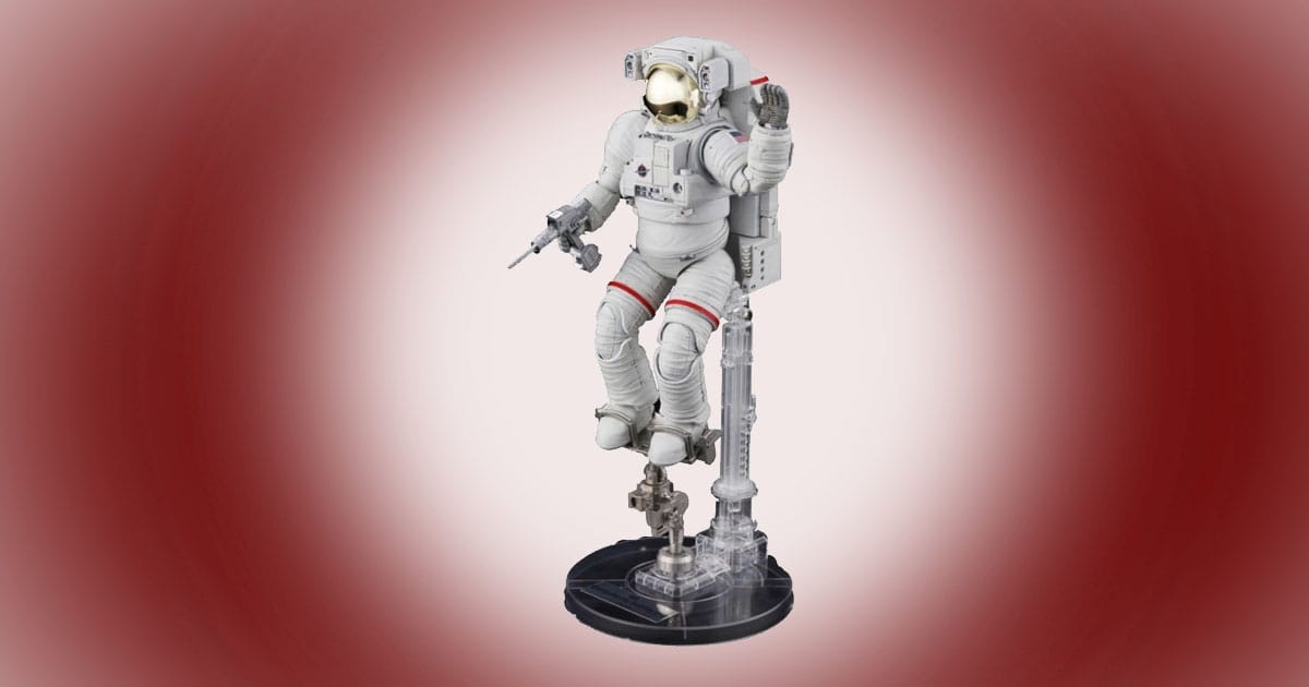 Model kit of an astronaut in an ISS extravehicular mobility unit with backpack, mounted on a clear display stand.