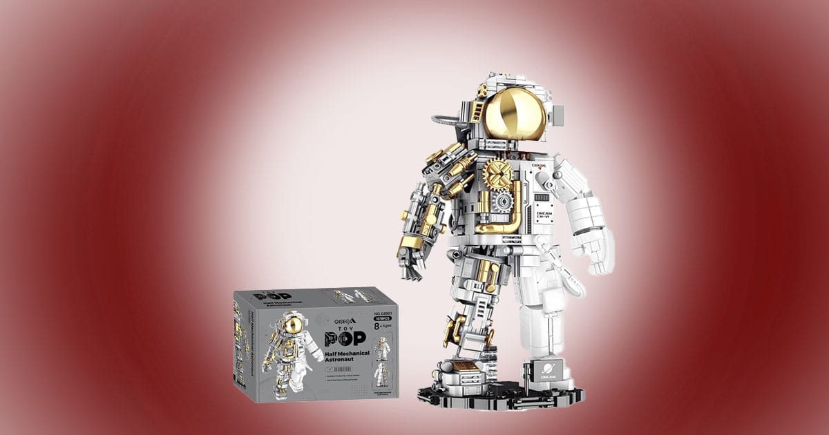 Half mechanical astronaut building block model with gold visor and exposed internal components, shown assembled on a display stand next to its box.