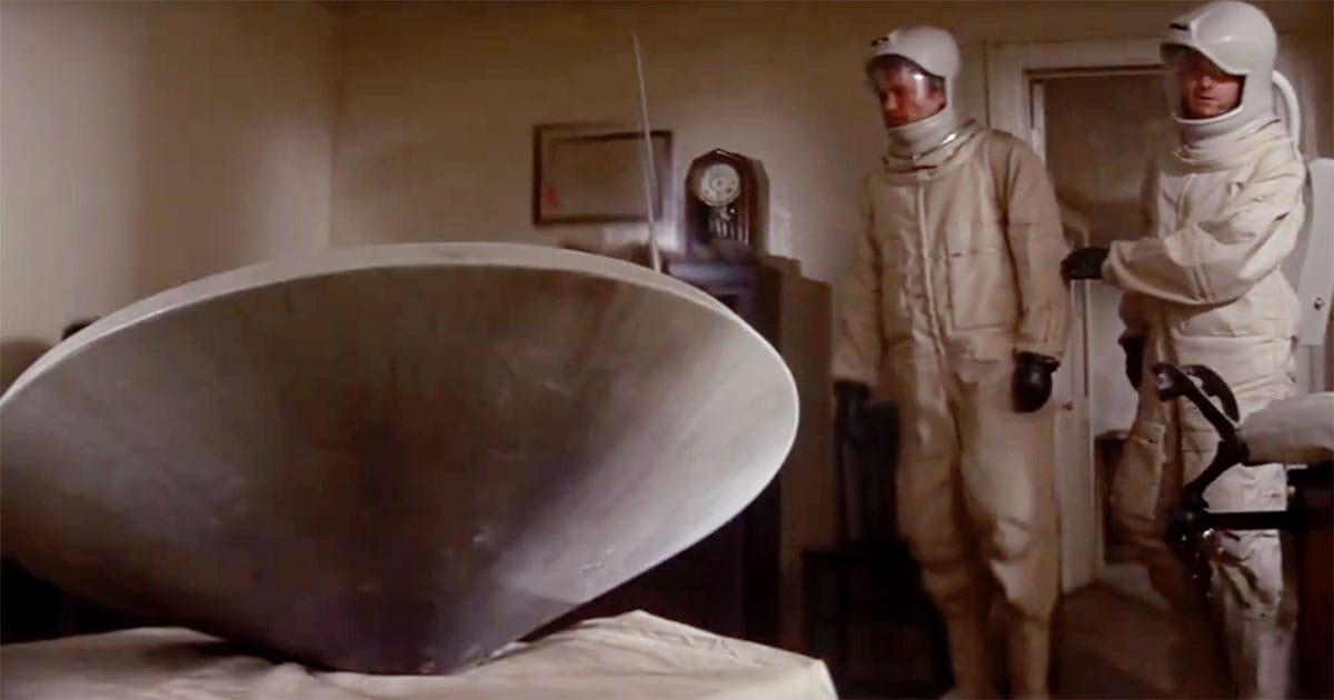 A scientist sits alone facing a circular monitoring screen inside a controlled facility in the film "The Andromeda Strain" (1971).