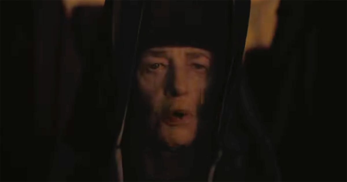 Reverend Mother Gaius Helen Mohiam in Dune 1984 shown veiled in darkness, her face partially visible with a solemn expression.