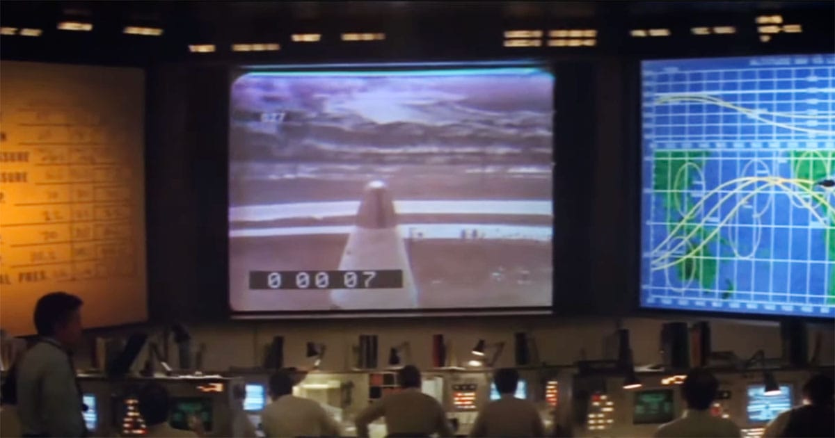 Mission control staff watching telemetry charts and video screens during the staged Mars mission in the 1977 film Capricorn One.
