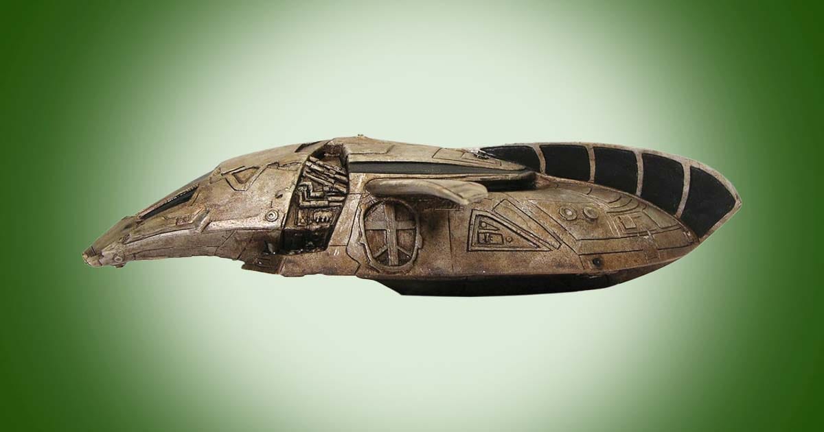 Serenity Inara’s Shuttle Ornament collectible spaceship model on green background, science fiction Firefly-inspired Christmas ornament for collectors and fans.