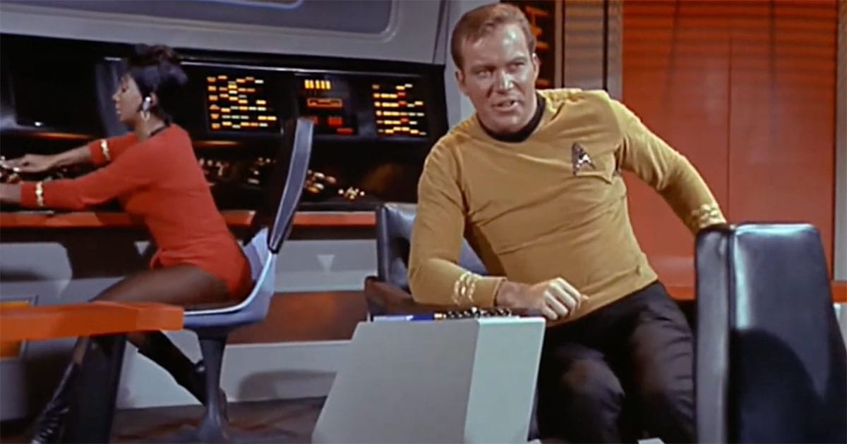 The captain rising from his chair on the Starship Enterprise bridge, showing the chair’s swivel and practical design.