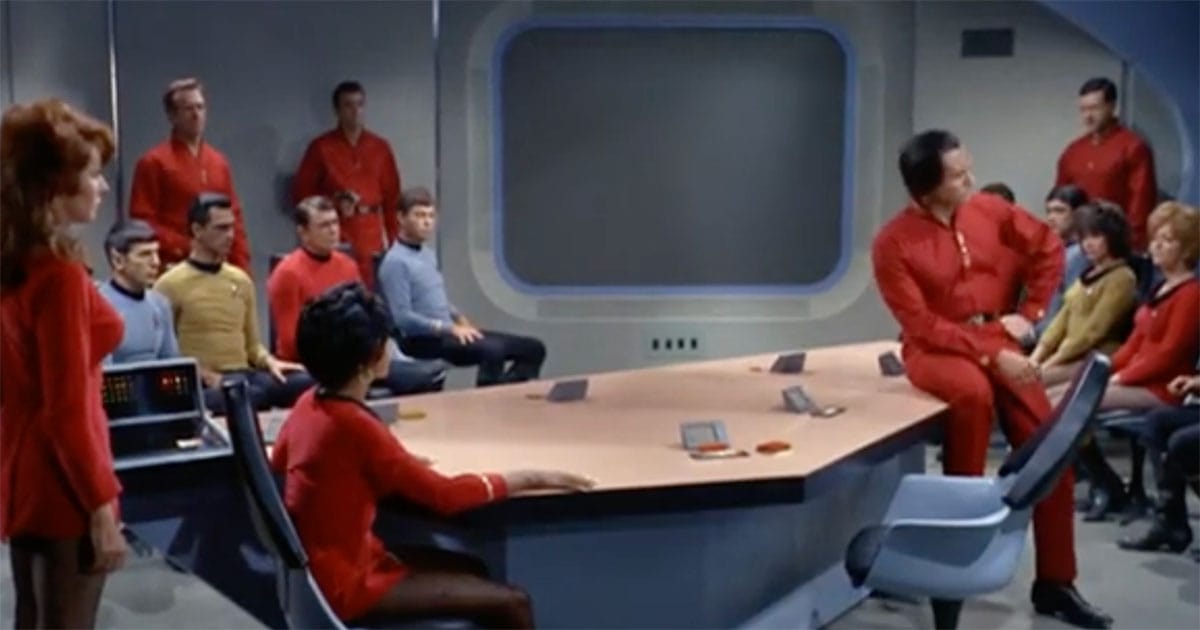Khan Noonien Singh seated among Starfleet officers during a tense hearing scene in Star Trek The Original Series Space Seed