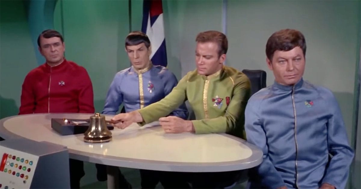Star Trek The Original Series crew seated thoughtfully during a briefing scene conveying reflection and cautionary themes.